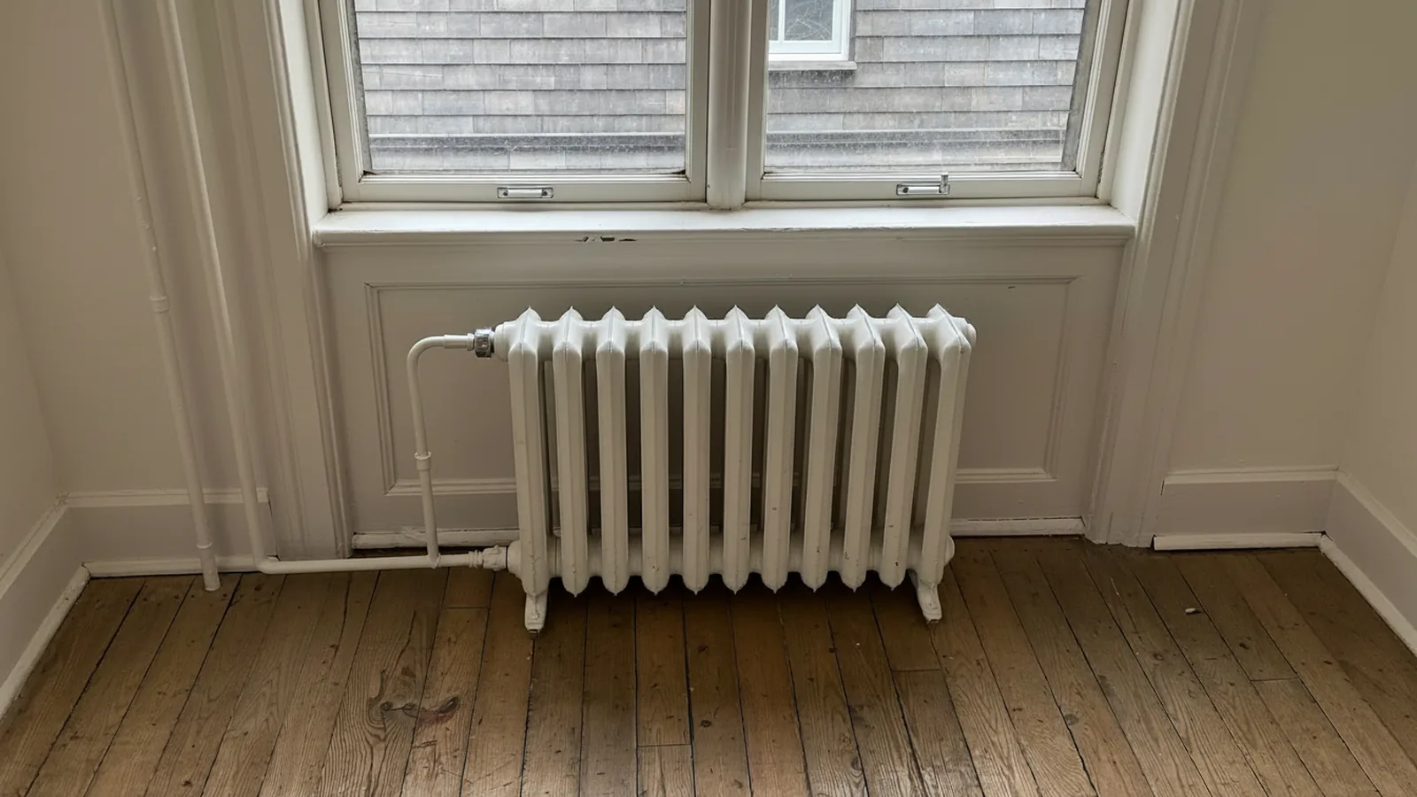 Cast iron radiator under a sunny window in an older Massachusetts home in winter
